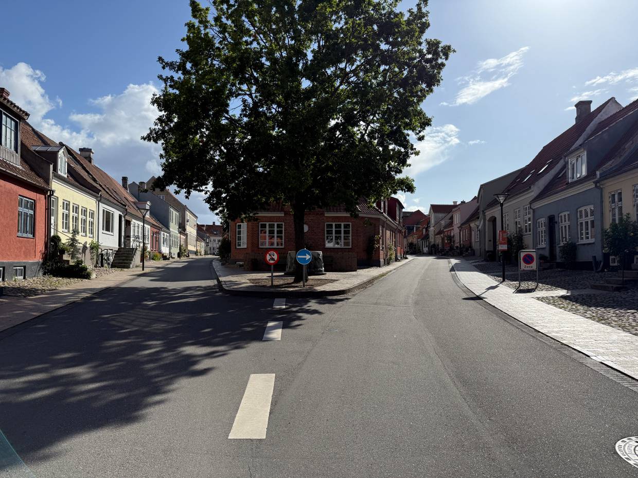 Blick durch zwei kleine Gassen durchtrennt von einem kleinen Platz mit Baum und Brunnen