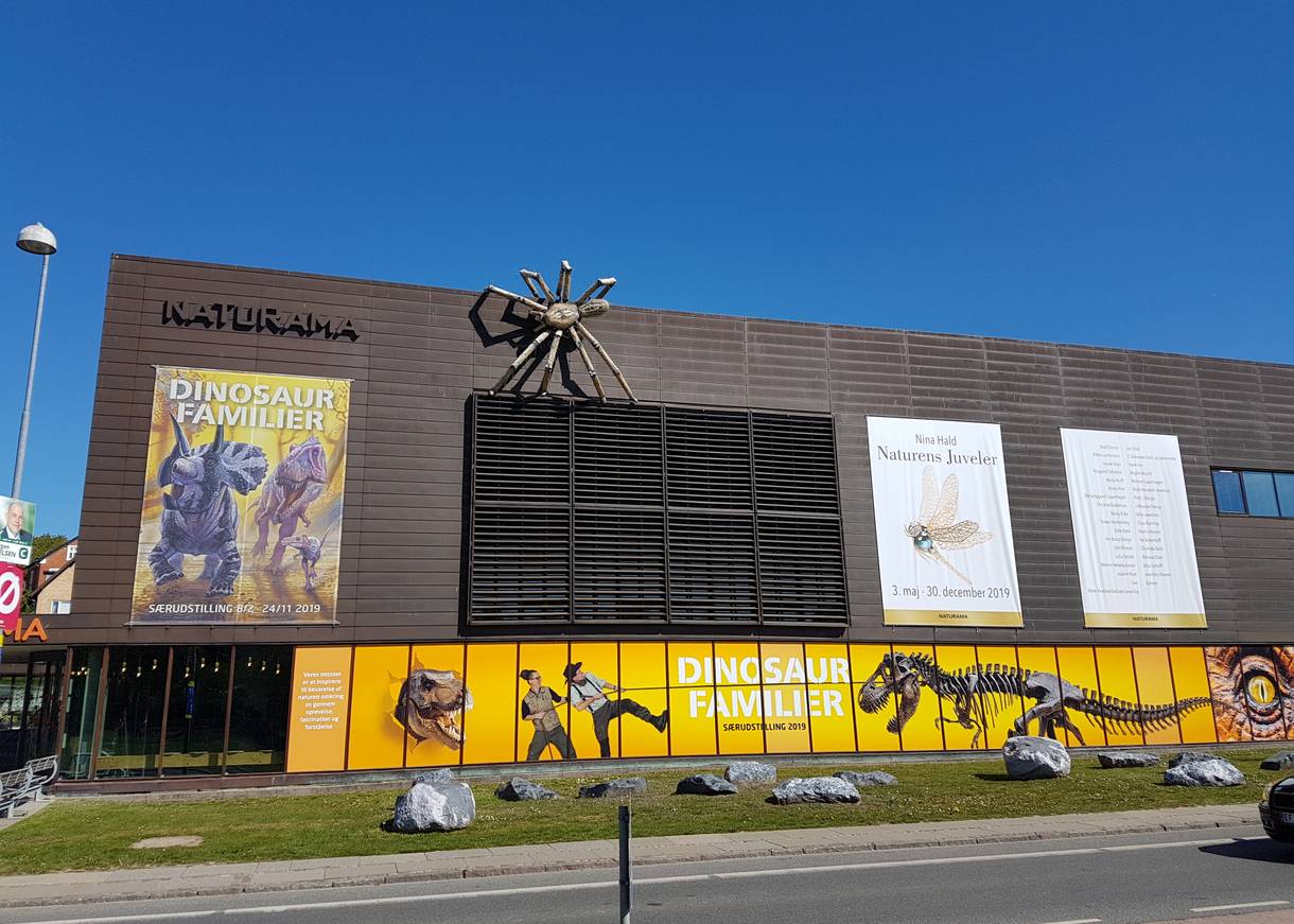 Moderner Museumsbau mit Werbung für eine Dinosaurierausstellung