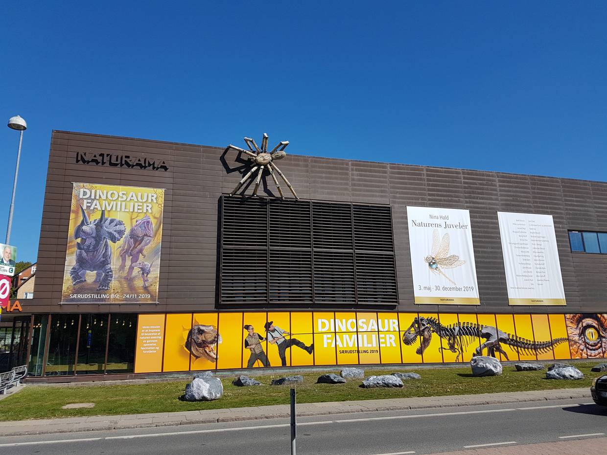 Moderner Museumsbau mit Werbung für eine Dinosaurierausstellung