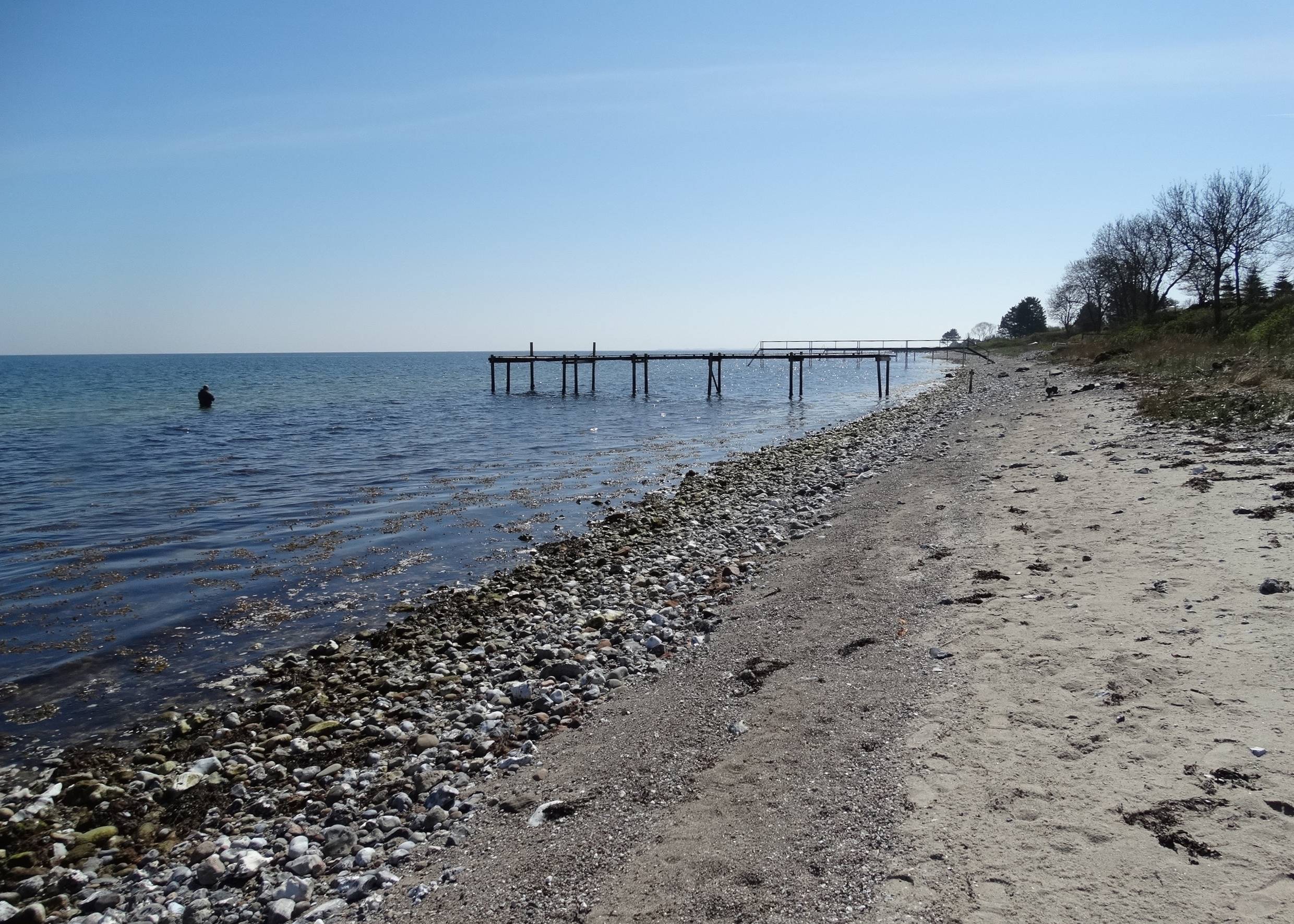 Steiniger Strand mit einem Badesteg