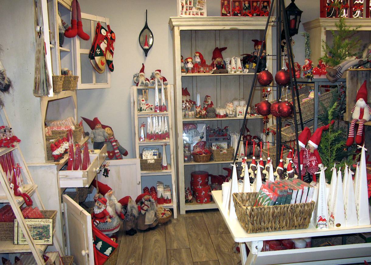 Kerzen und viel Weihnachtsdeko in den Regalen eines geschäfts