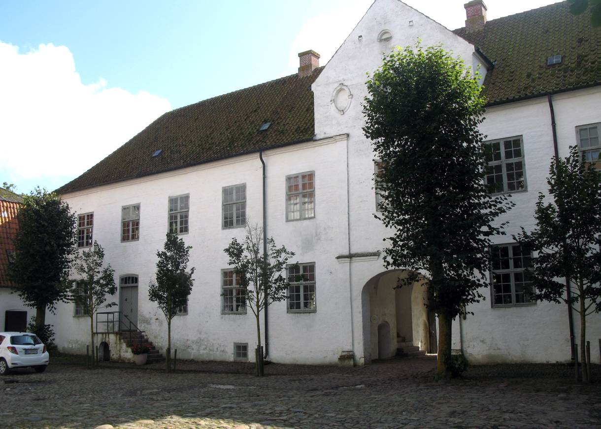 Weiße altes Gusthaus, davor ein Platz dermit Feldsteinen gepflastert ist