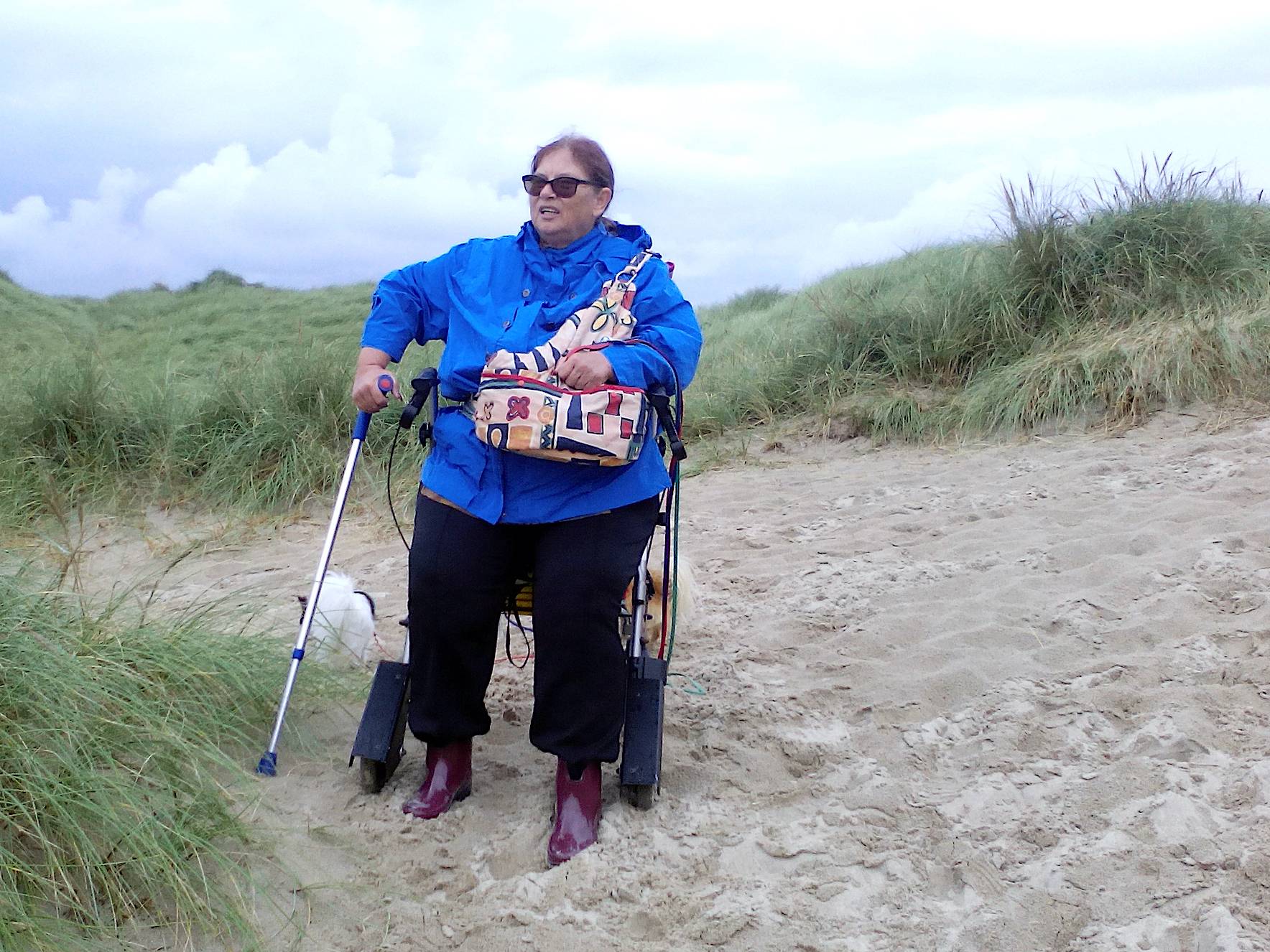 Frau mit Rollator in den Dünen