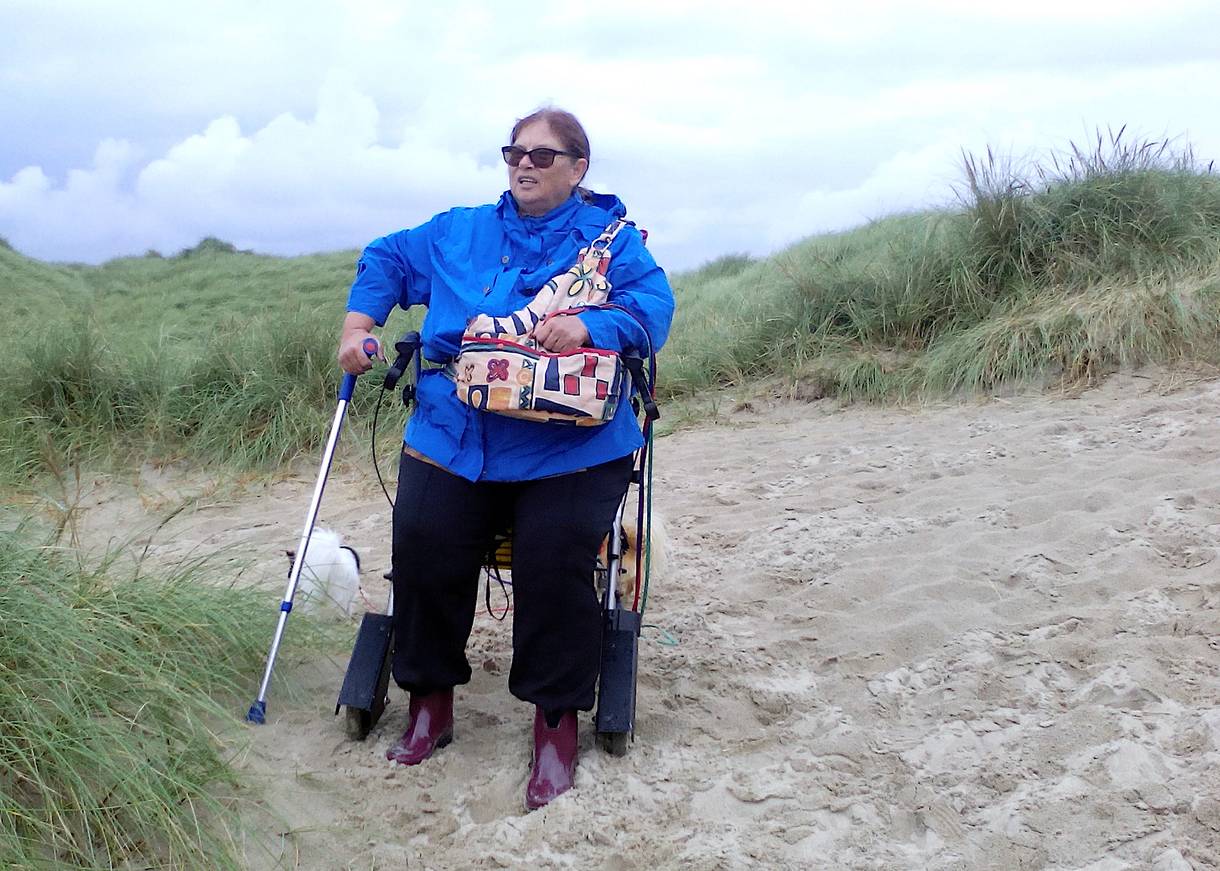 Frau mit Rollator in den Dünen