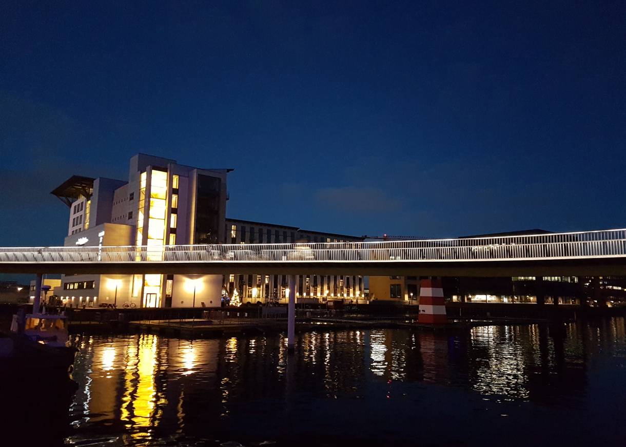 beleuchtete Fahrradbrücke über den Binnenhafen bei Nacht