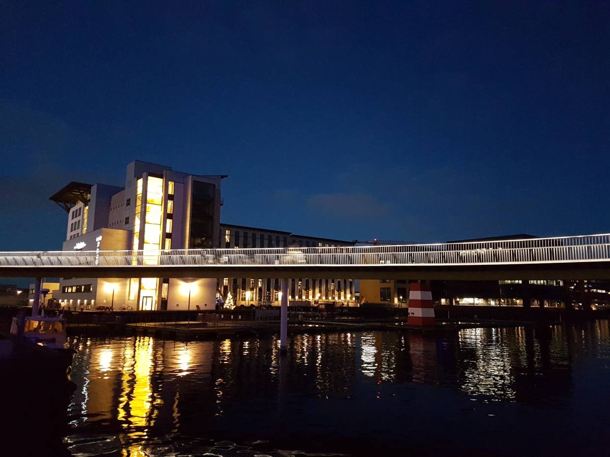 beleuchtete Fahrradbrücke über den Binnenhafen bei Nacht
