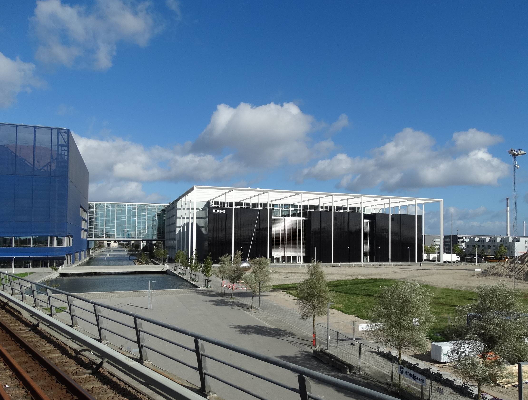 Zwei moderne Gebäude, die mit einem Gang über drei Wasserbecken vrbunden sind