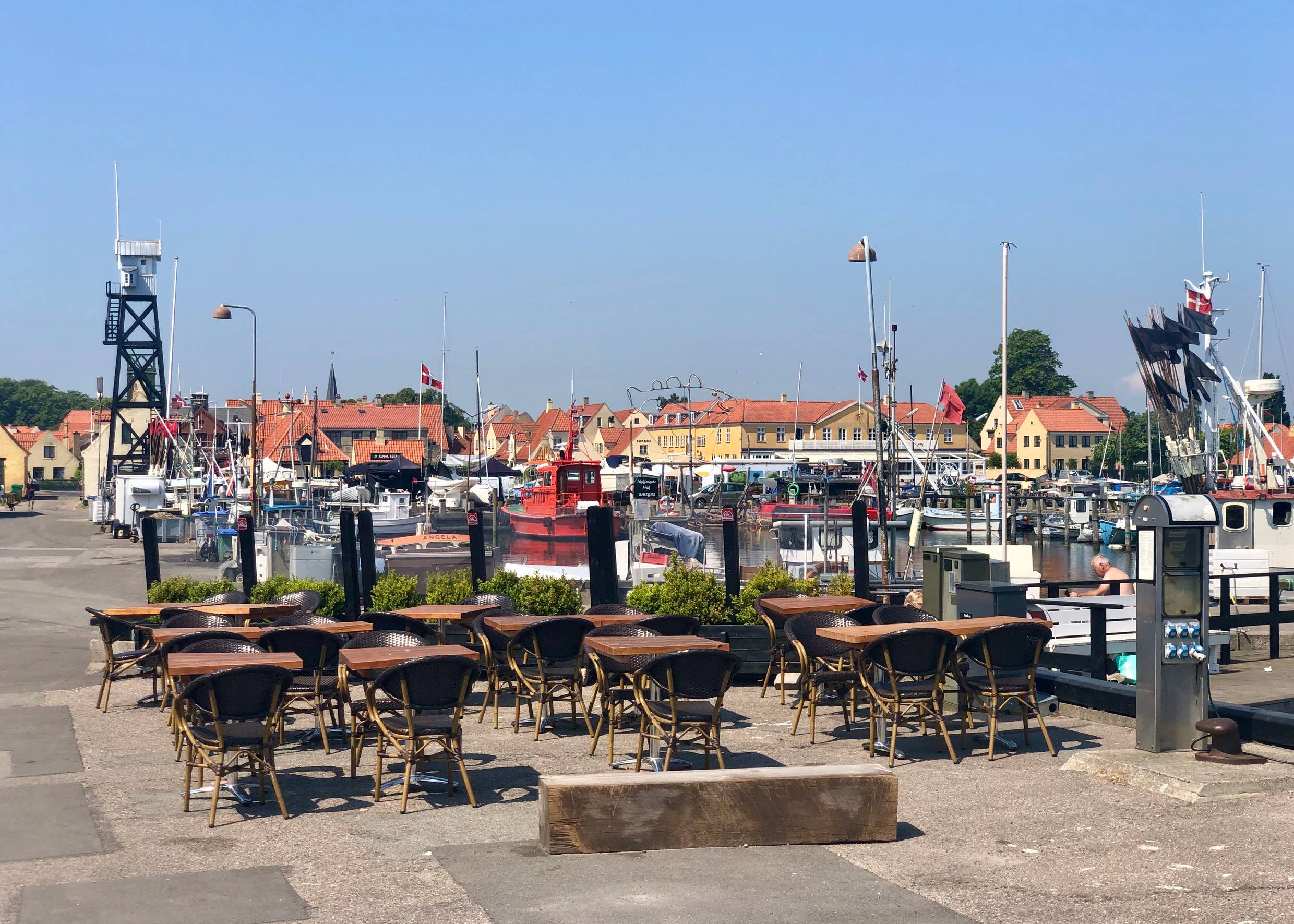 Restaurantterrasse am Hafen, im Hintergrund ein hölzerner Wachturm