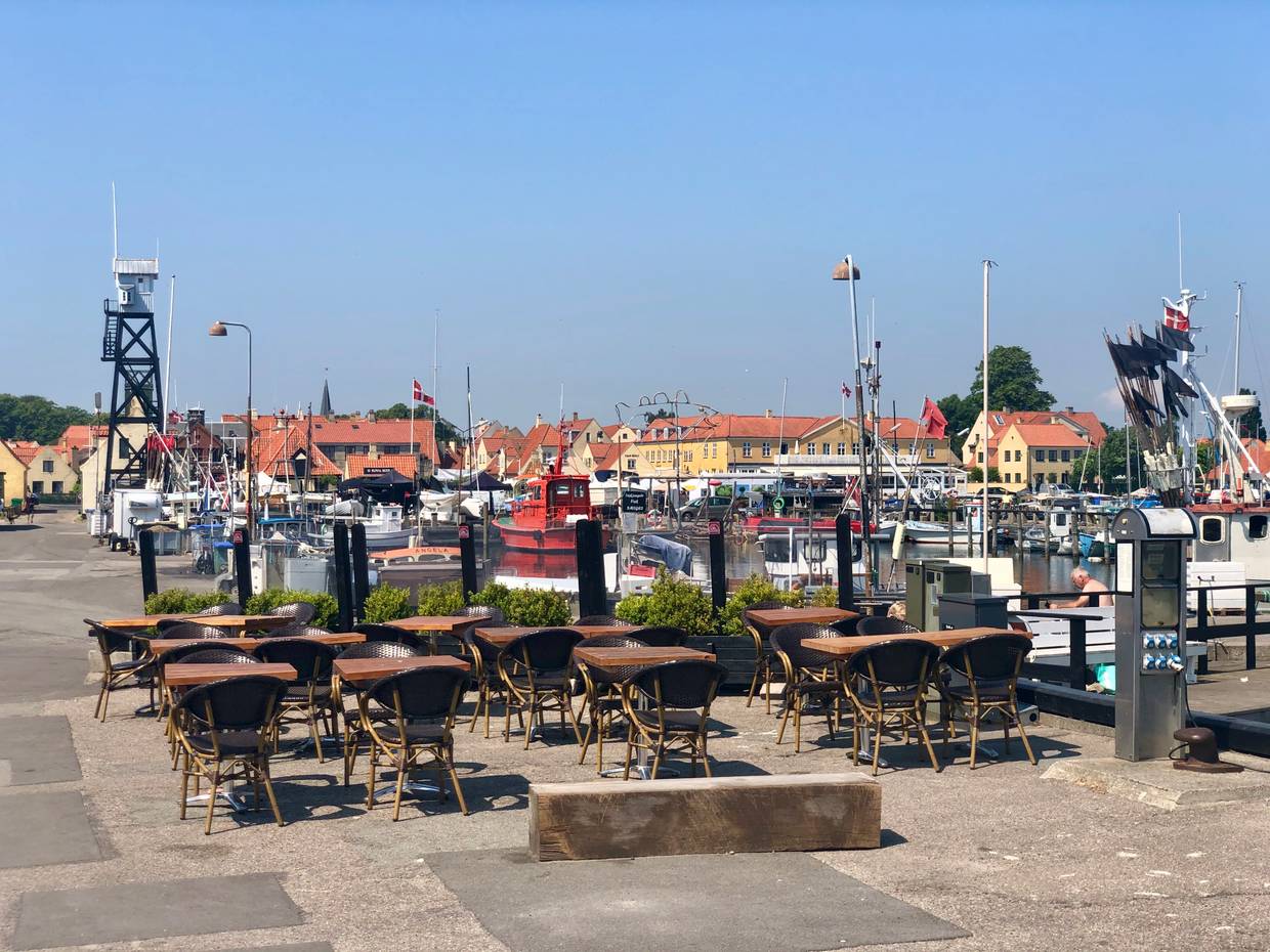 Restaurantterrasse am Hafen, im Hintergrund ein hölzerner Wachturm