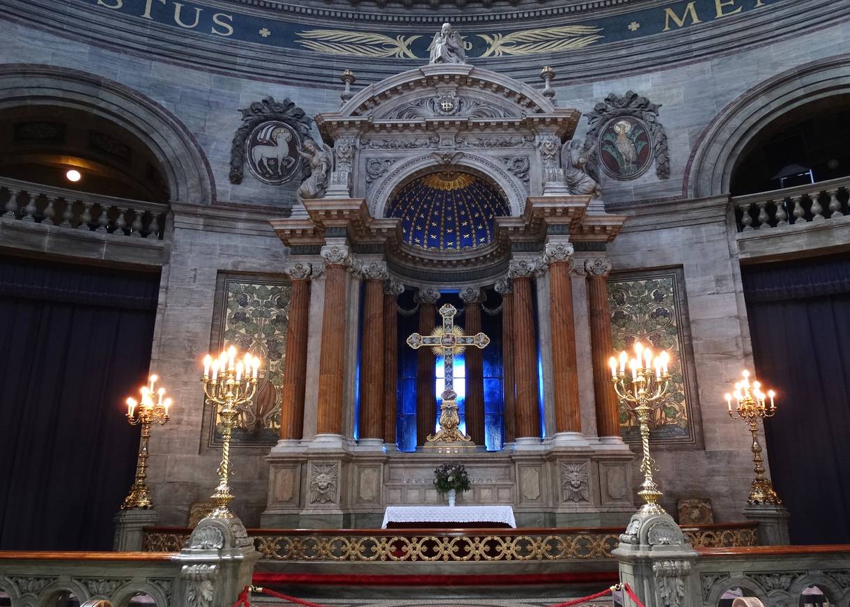Steinerner Altar mit einem Kreuz vor blauem Hintergrund