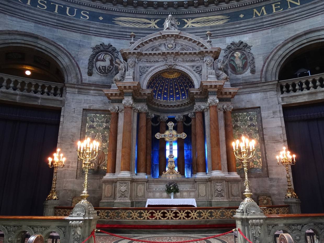 Steinerner Altar mit einem Kreuz vor blauem Hintergrund