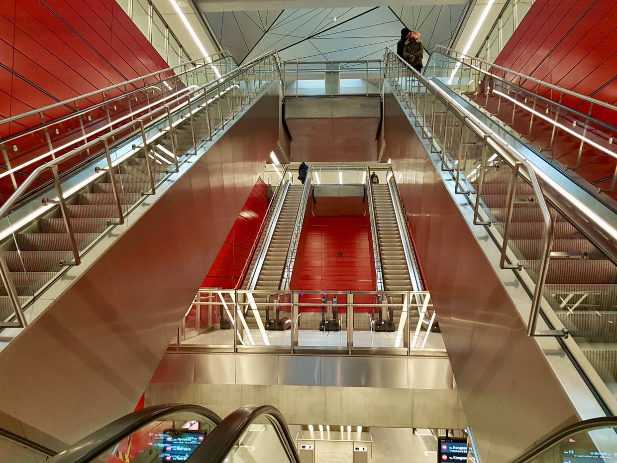 Verschieden lange Rolltreppen vor einer roten Wand