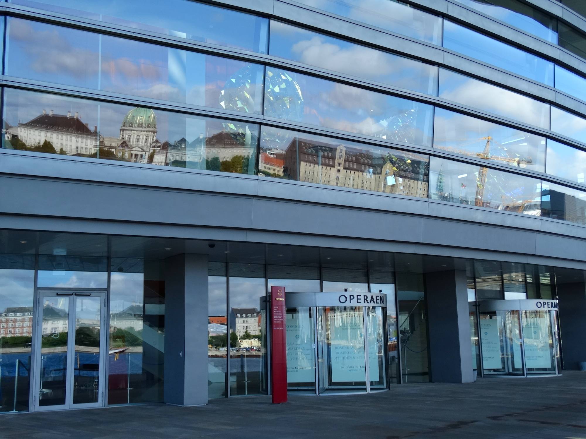Glasfront des Opernhauses, in dem sich das Schloss Amalienbirg spiegelt