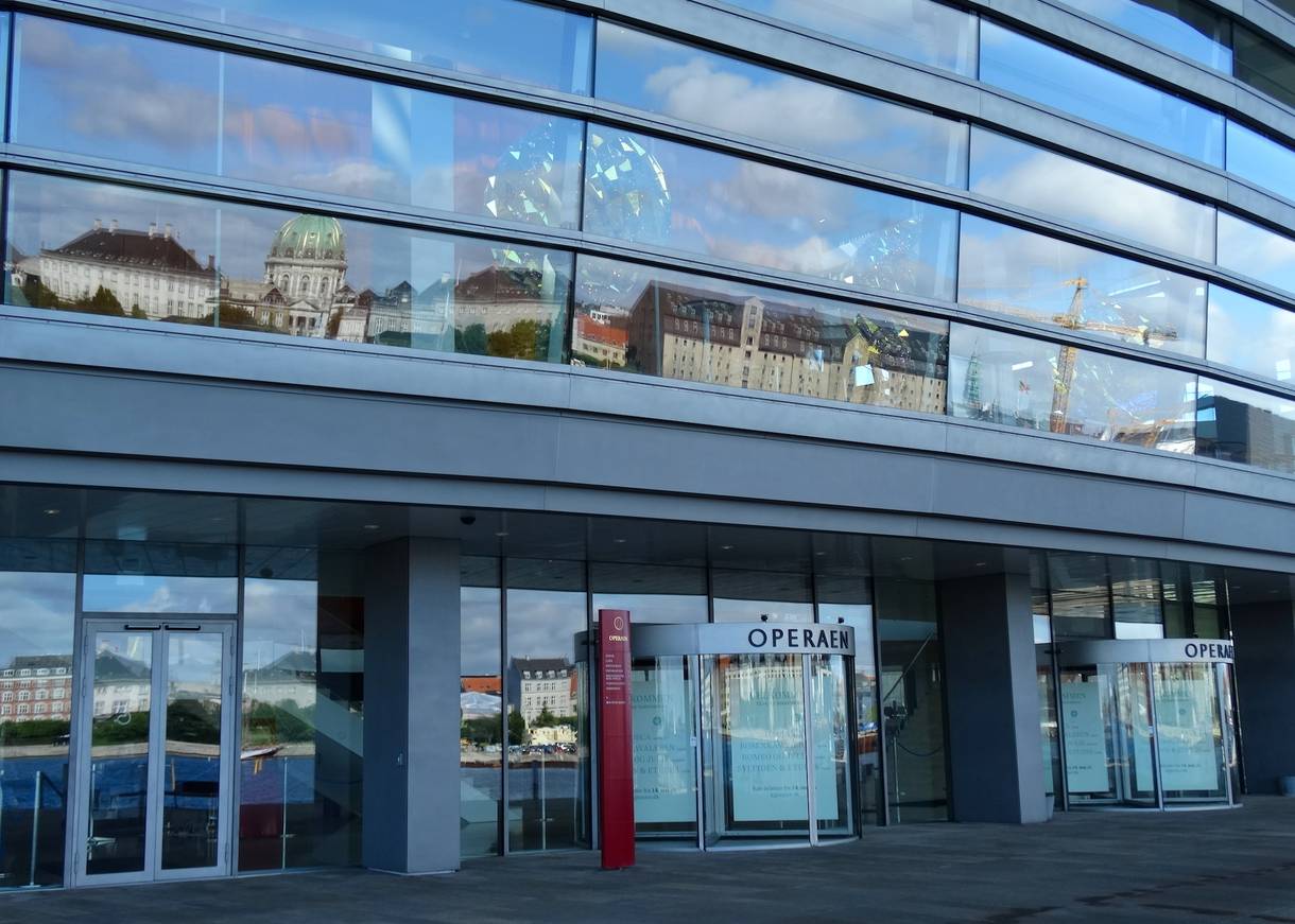 Glasfront des Opernhauses, in dem sich das Schloss Amalienbirg spiegelt