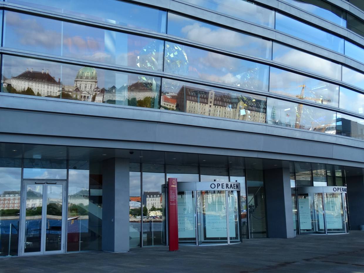 Glasfront des Opernhauses, in dem sich das Schloss Amalienbirg spiegelt
