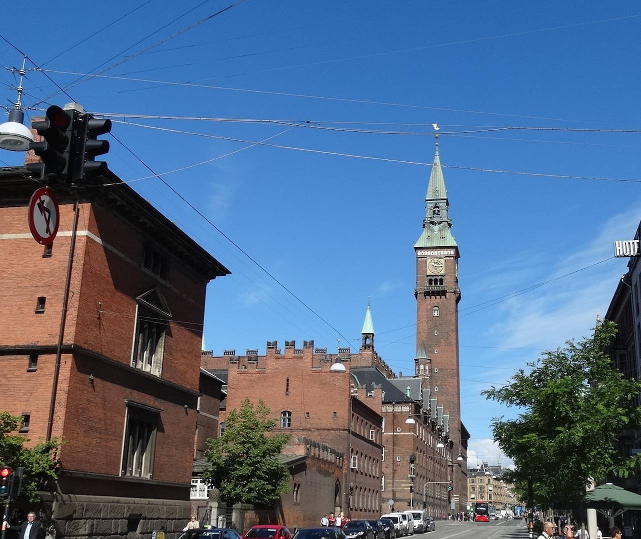 Der Rathausturm am Ende einer Straße mit Radfahrern