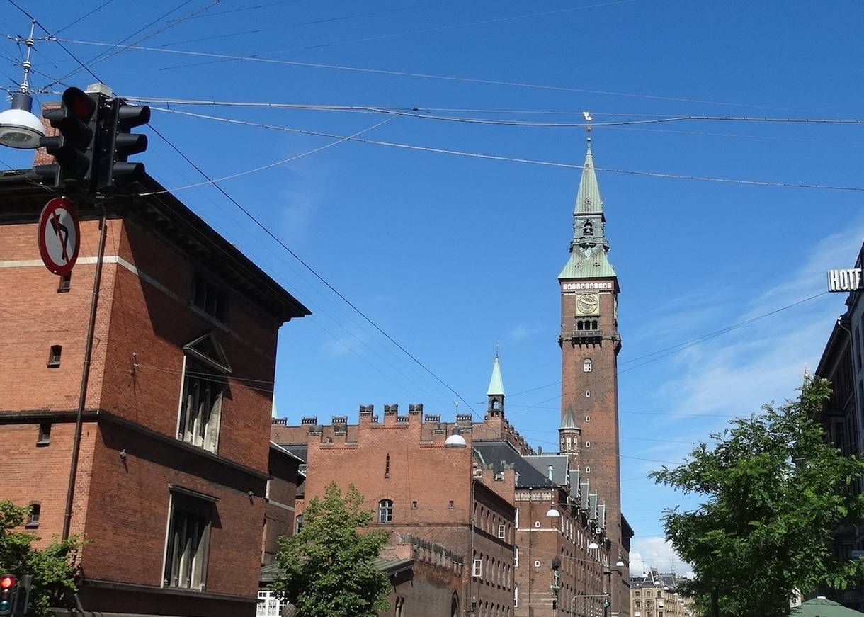 Der Rathausturm am Ende einer Straße mit Radfahrern
