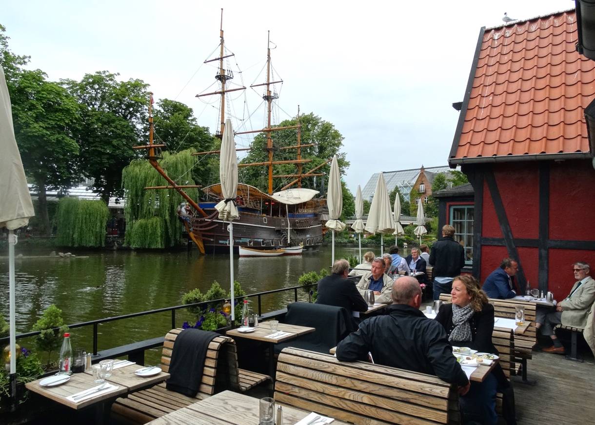 Restaurantterrasse am See mit Schiff im Hintergrund