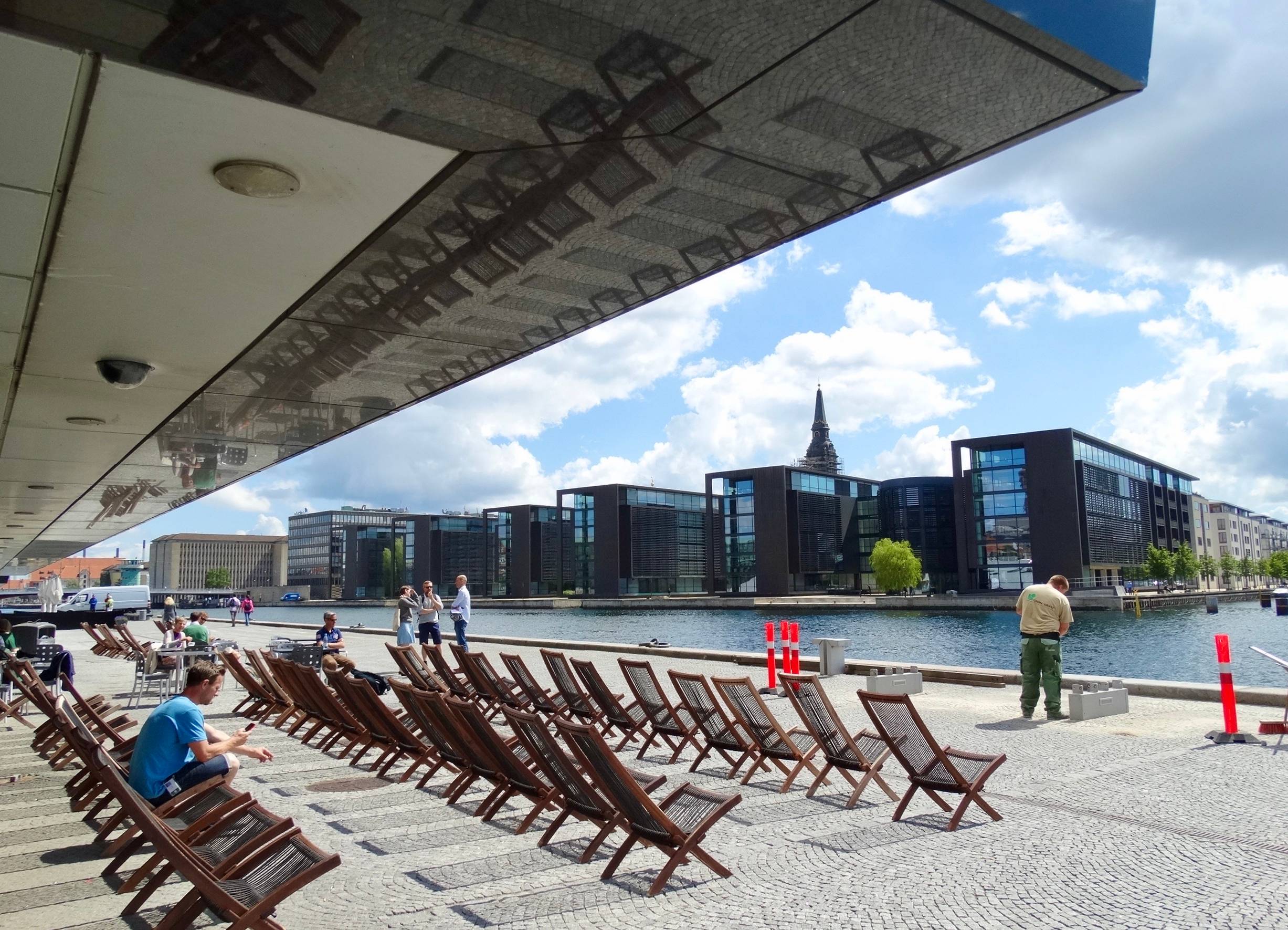 Liegestühle am Hafen unter dem Vordach der Bibliothek