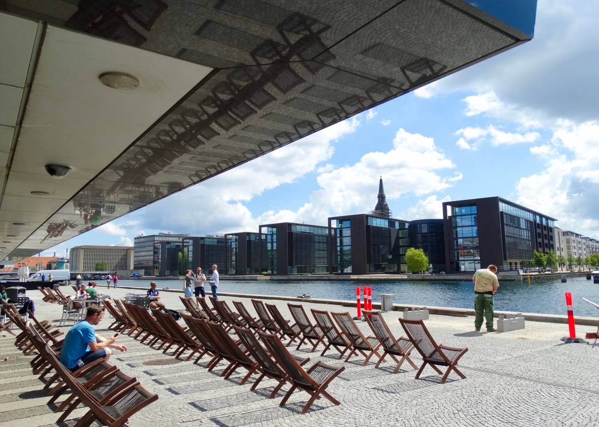 Liegestühle am Hafen unter dem Vordach der Bibliothek