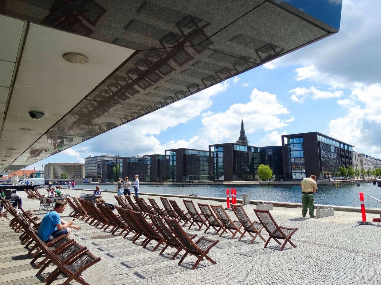 Liegestühle am Hafen unter dem Vordach der Bibliothek