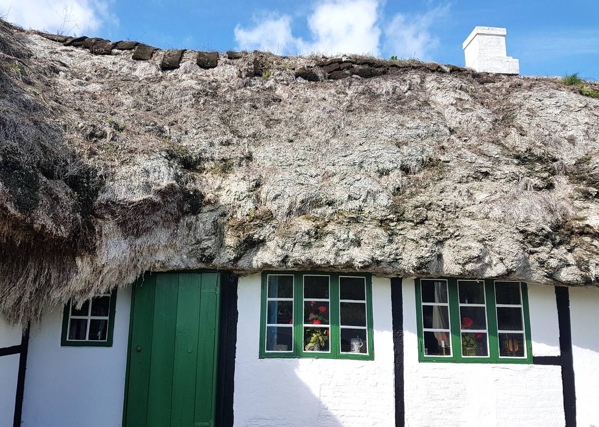 Grüne Fenster in einem weißen Fachwerkhaus