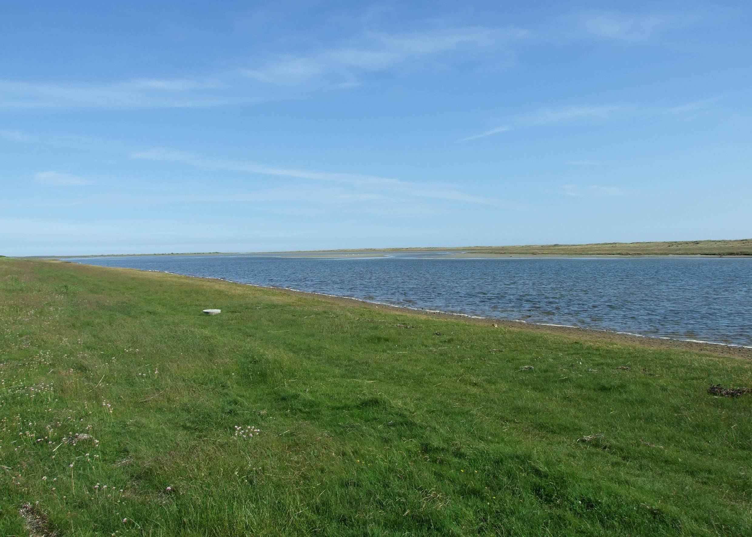 Ein Kanal zwischen zwei grünen Wiesen