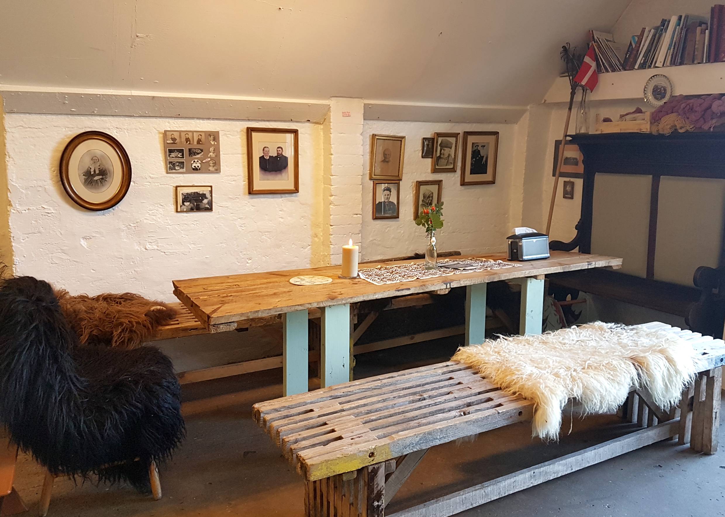 Sitzecke im Café mit Schaffellen und einfachen Holzmöbeln
