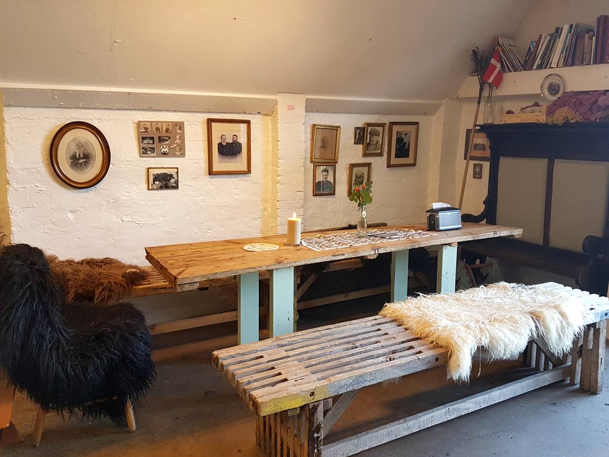 Sitzecke im Café mit Schaffellen und einfachen Holzmöbeln