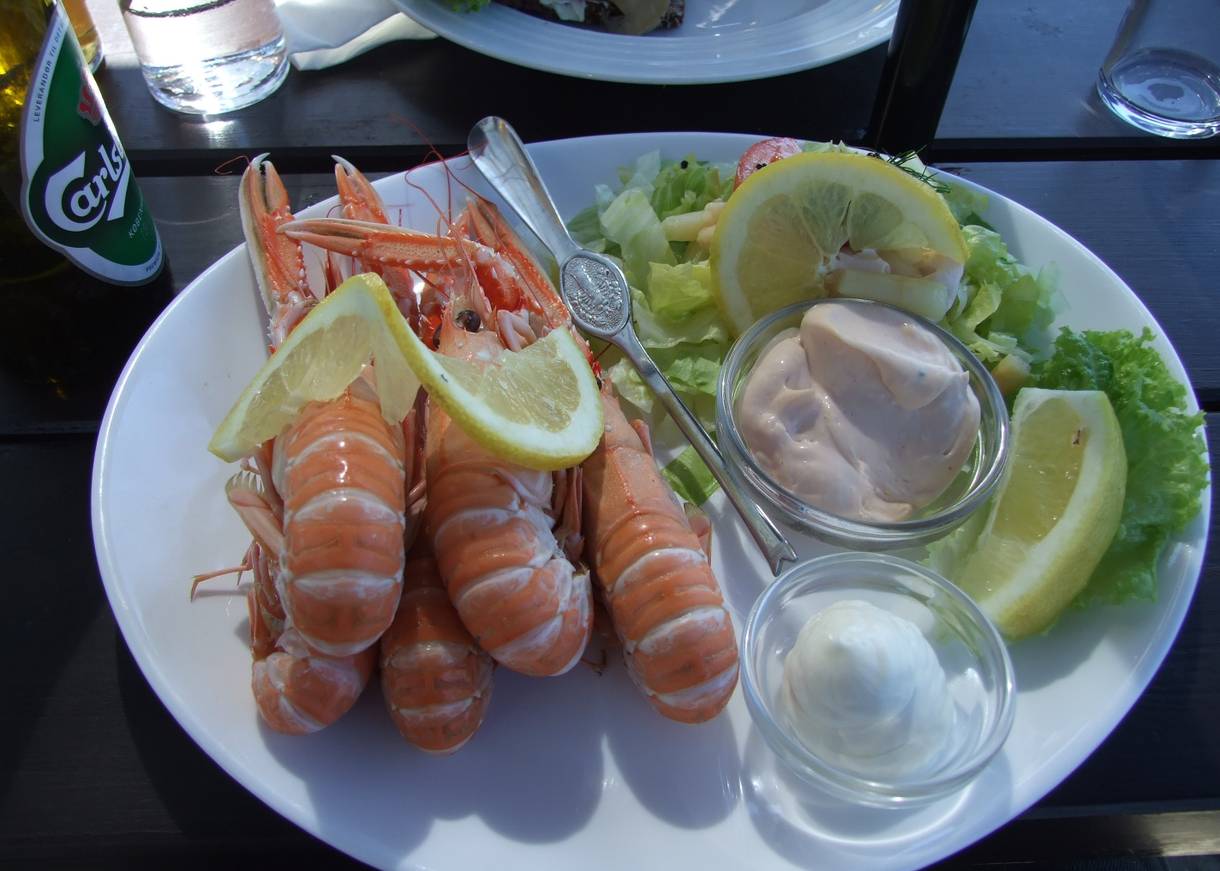 Teller mit kleinen Hummern, garniert mit Mayonaise und Zitronen