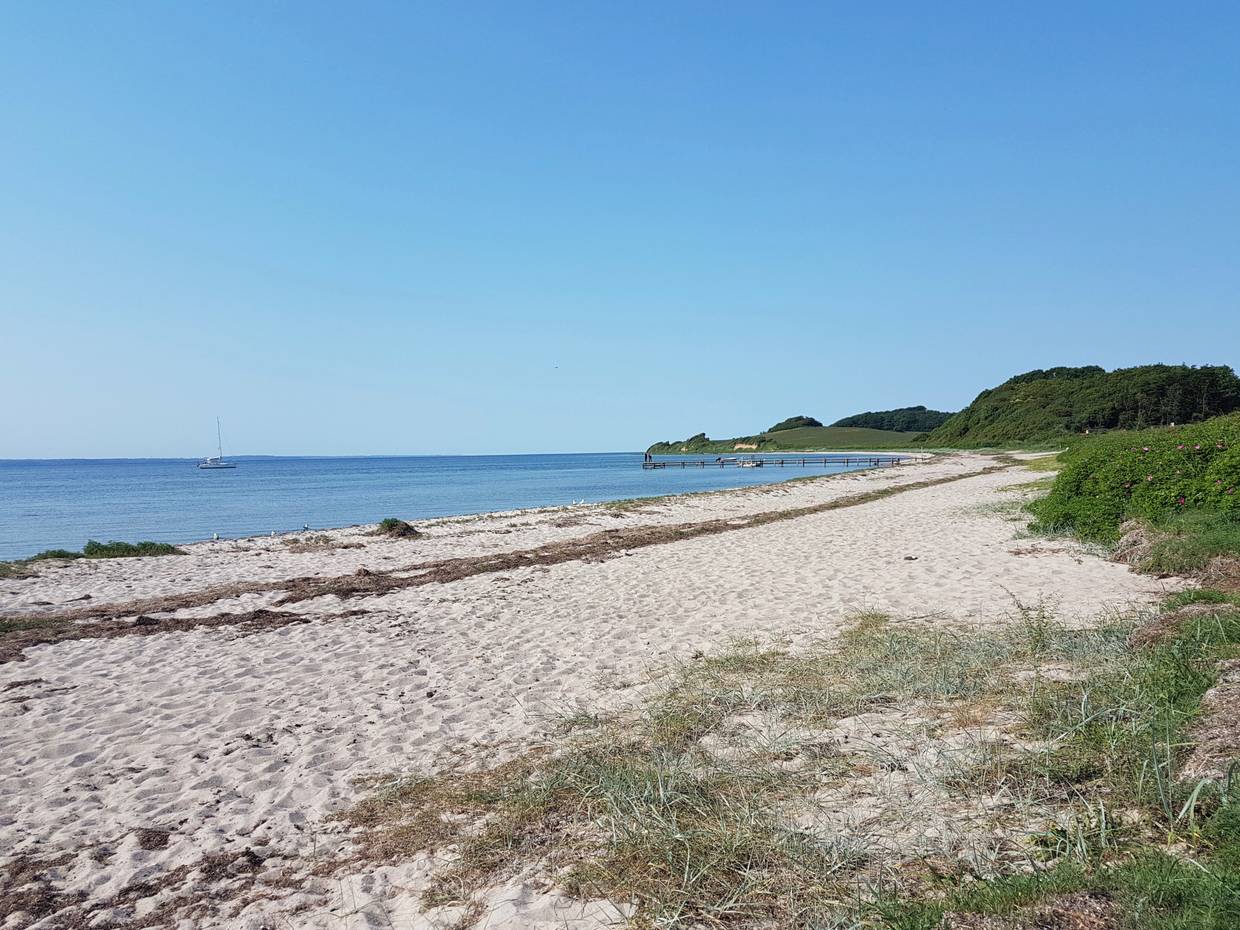 Blick über einen langen Sandstrand bei windstillem Wetter