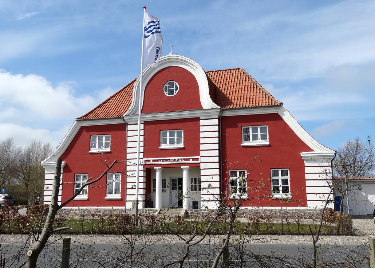 Sehr schmuckes rotes Haus mit einer Fahne davor