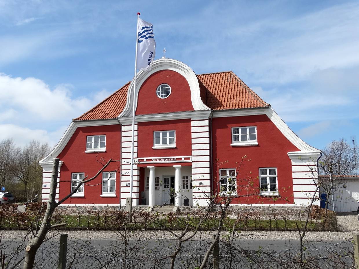 Sehr schmuckes rotes Haus mit einer Fahne davor