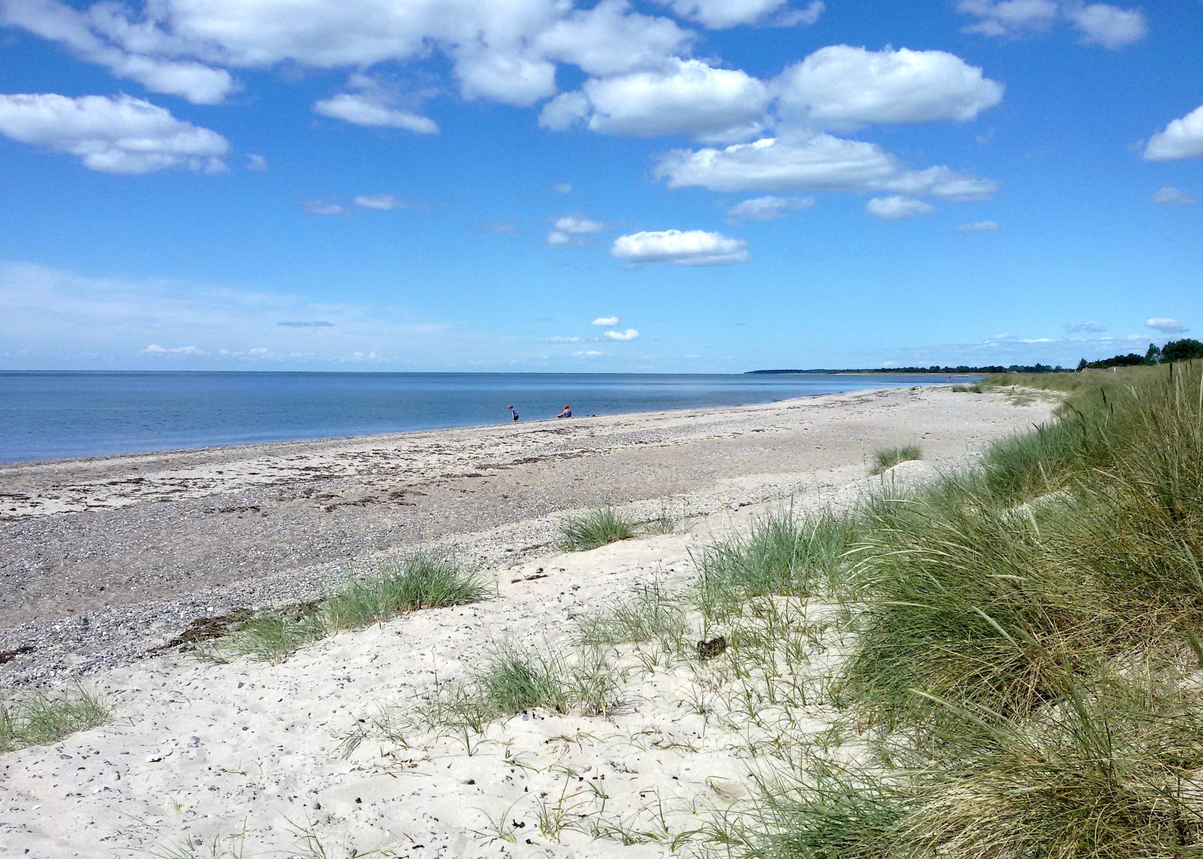 Etwas steiniger Strand mit Badegästen
