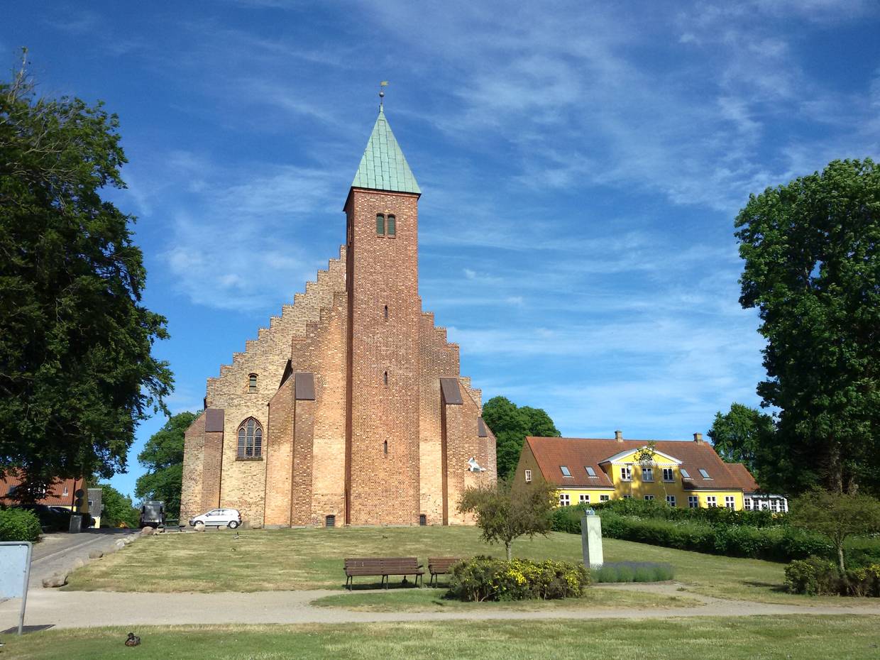 Sehr große Backsteinkirche mit ungewöhnlicher Form, davor eine Parkanlage