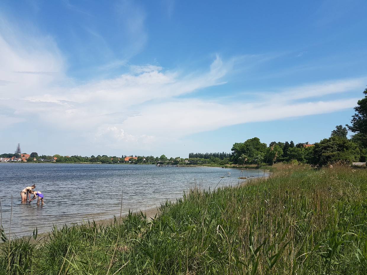 Badestelle mit der Silhouette einer Stadt im Hintergrund
