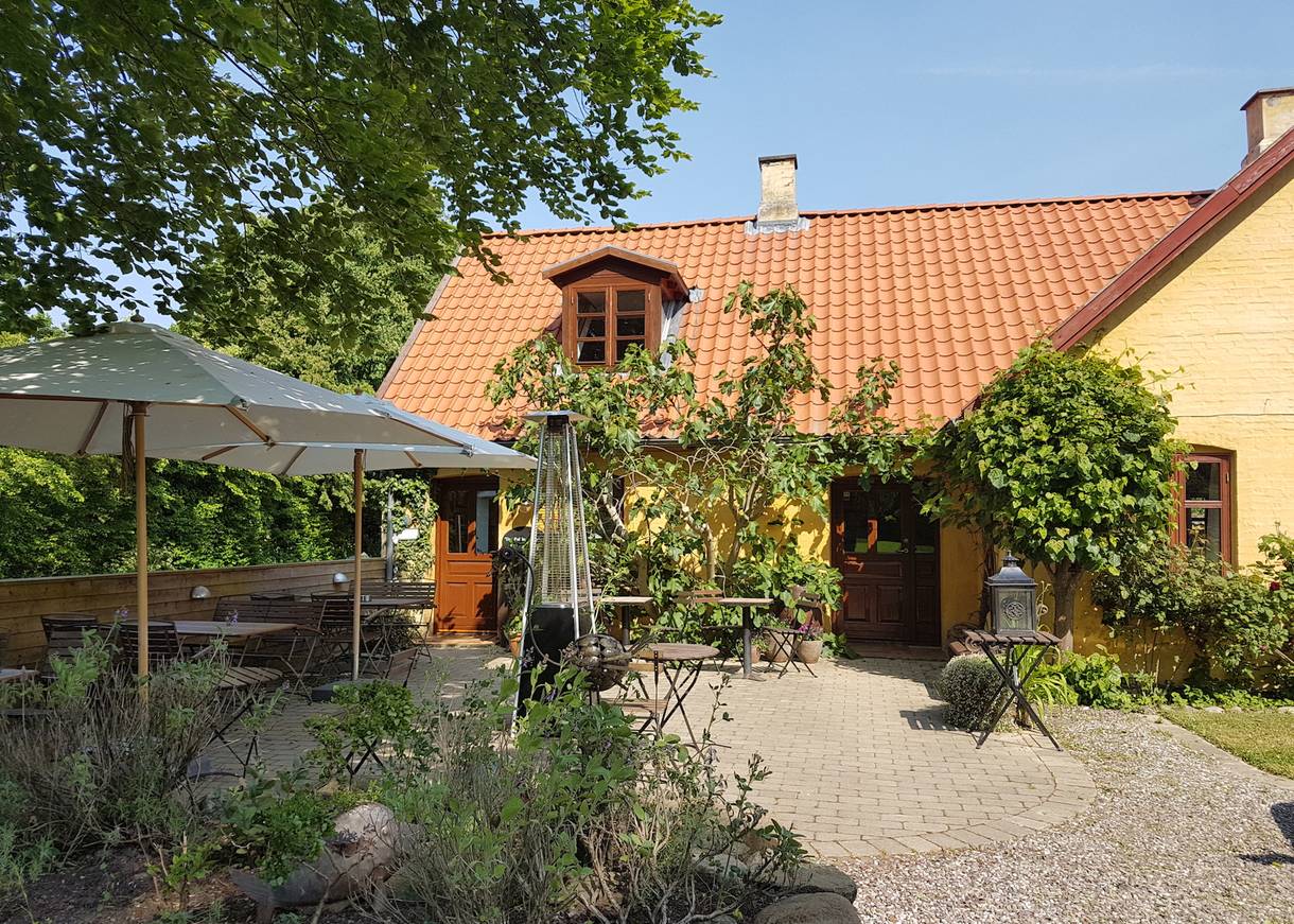 Lauschige Gastterrasse zwischen Blumen und Büschen
