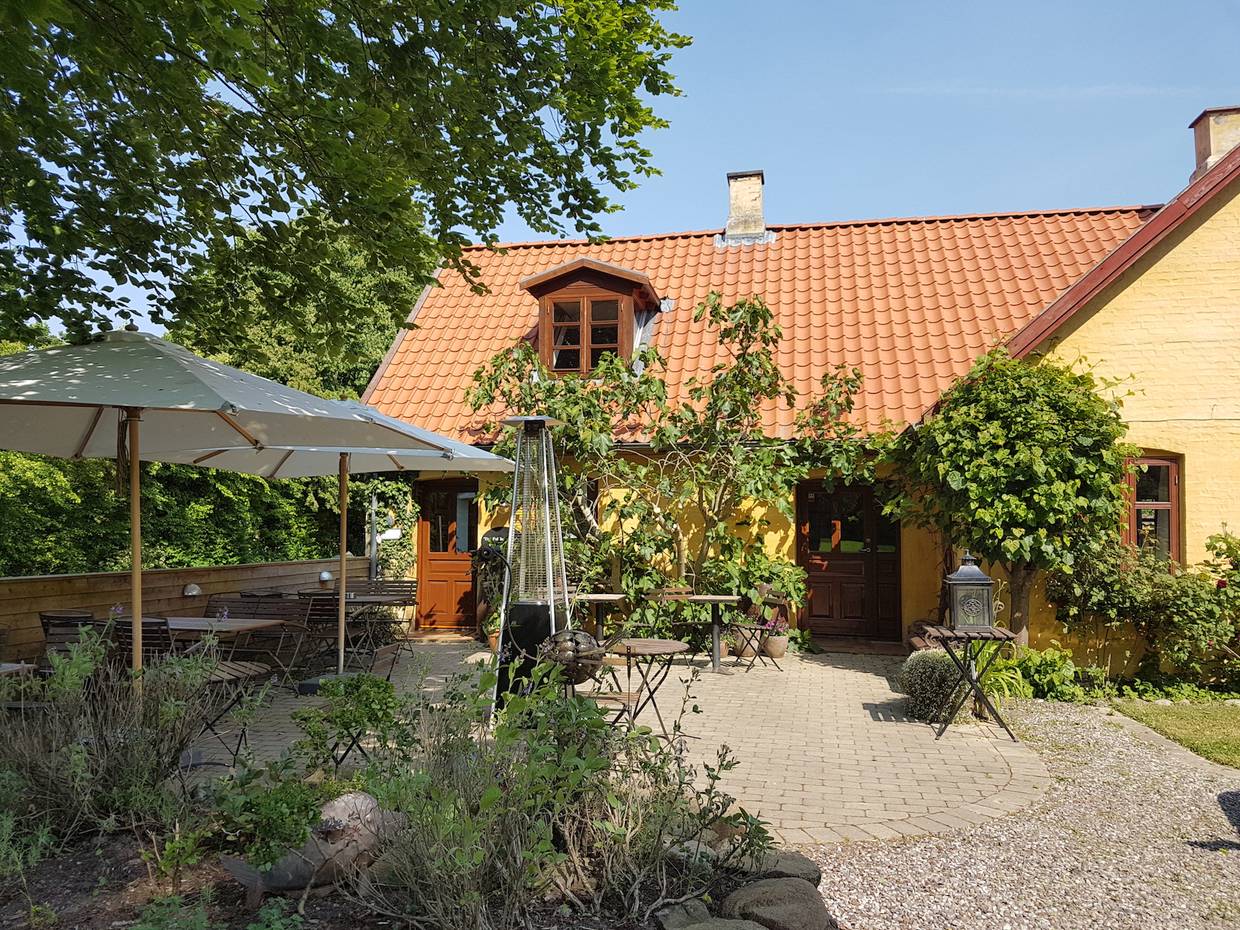 Lauschige Gastterrasse zwischen Blumen und Büschen