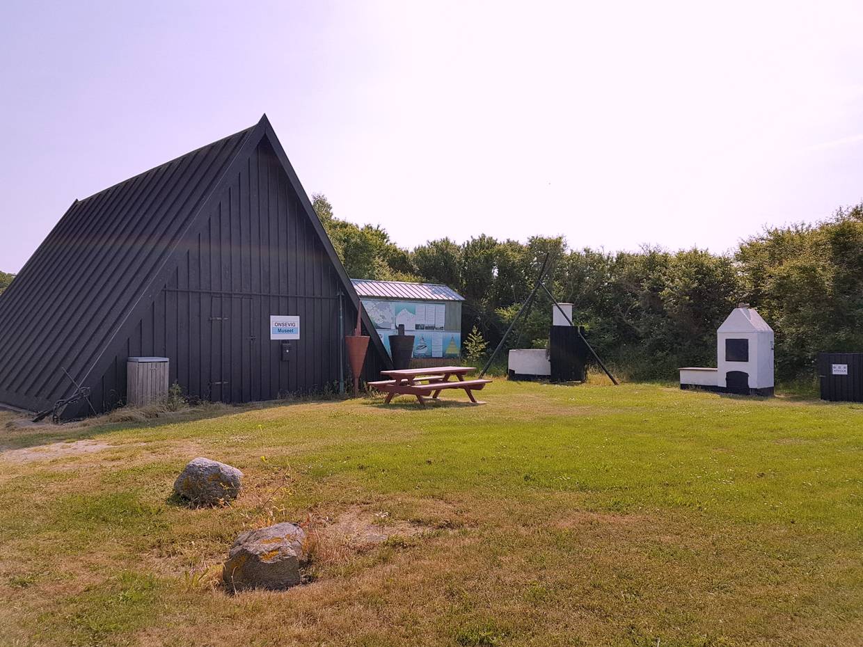 Kleines Nurdachhaus mit Hinweisschild Museum