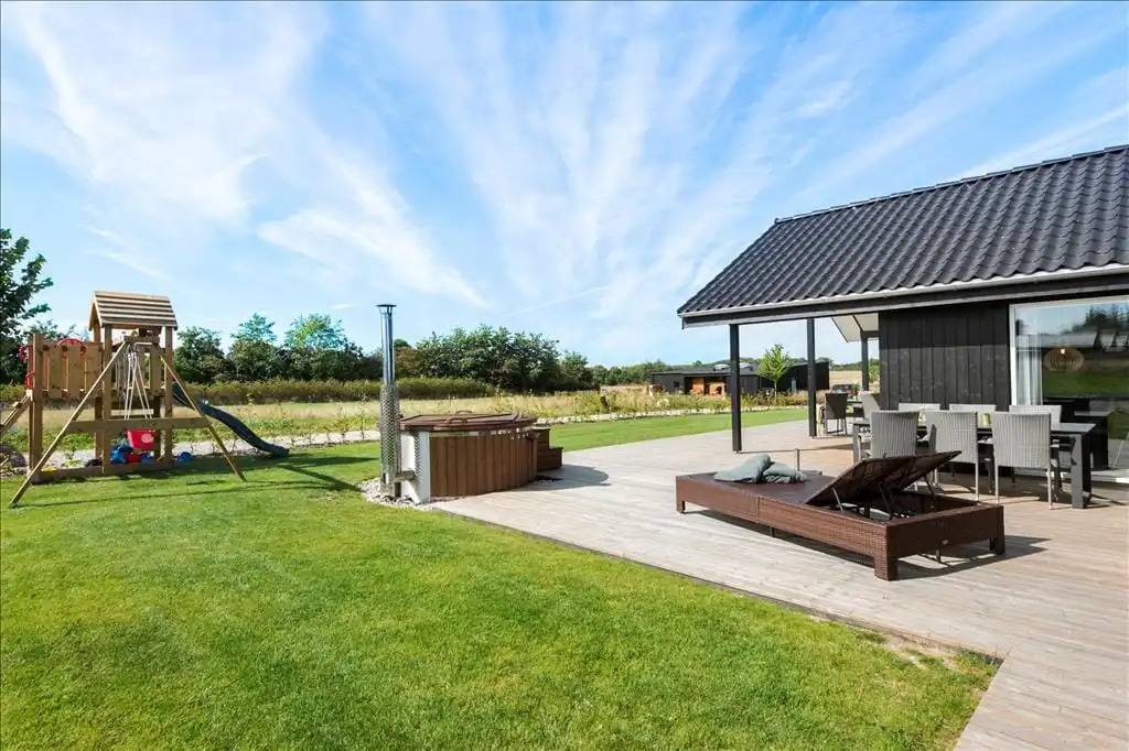 Fereinhausgrundstück mit Terrassenmöbeln, Badefass und Spielgeräten