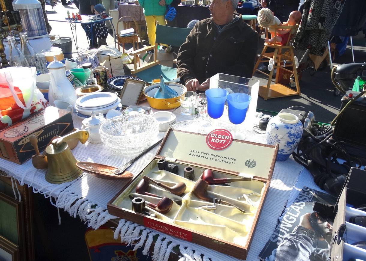 Flohmarktstand mit alten Geschirr und einem Pfeifenkasten