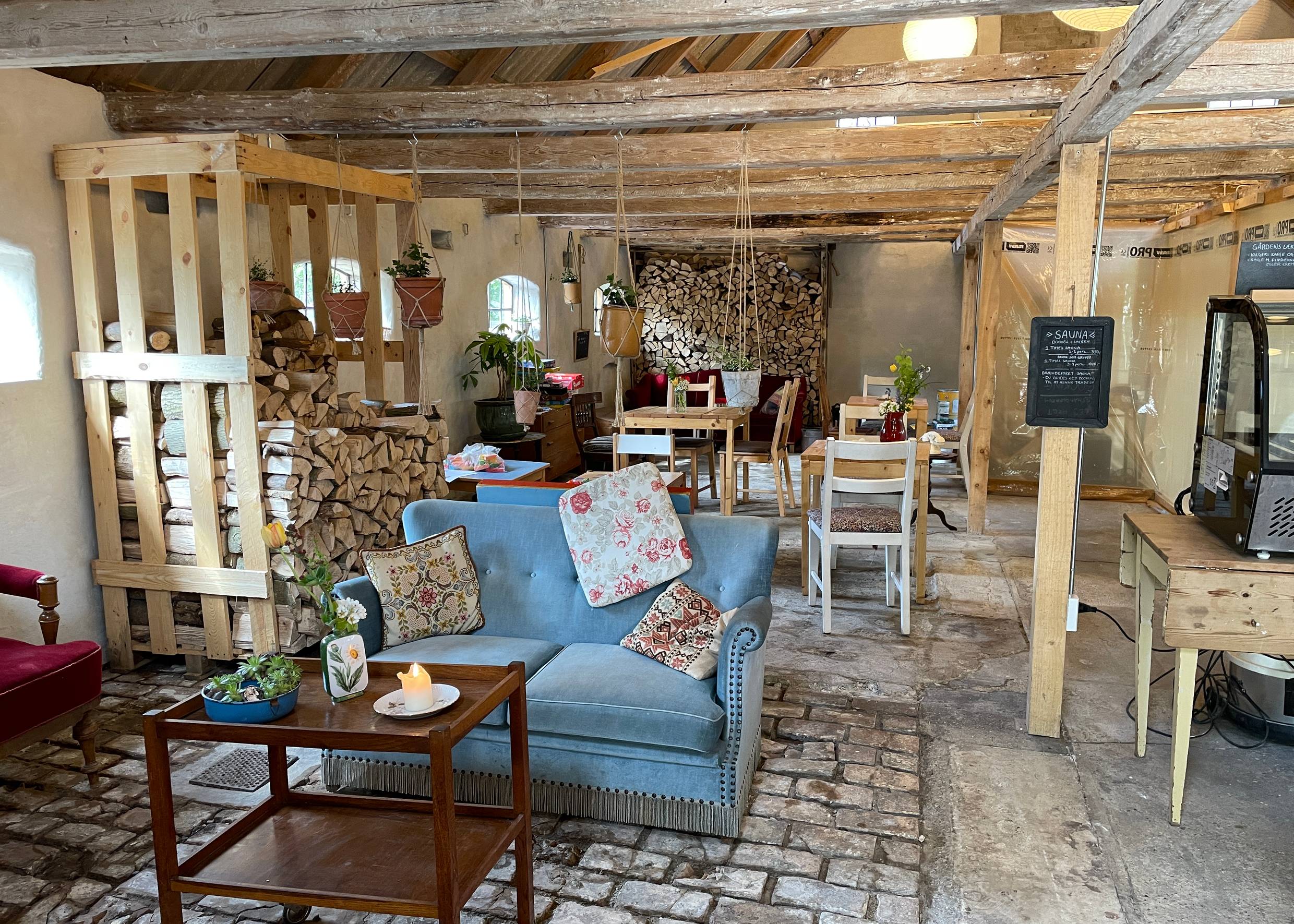 Blick in eine Scheune, die mit alten bunten Möbeln zum Café umgerüstet wurde
