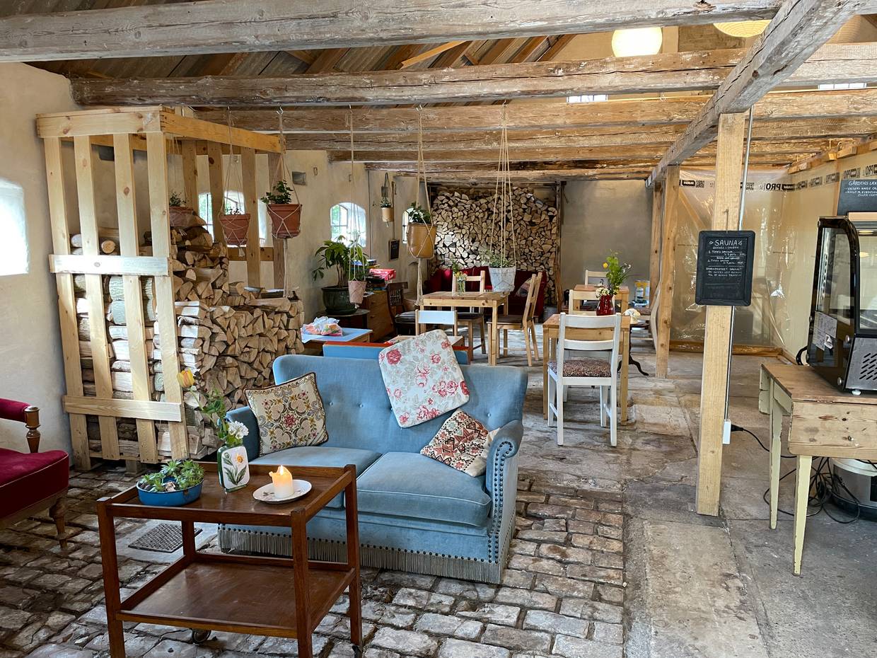 Blick in eine Scheune, die mit alten bunten Möbeln zum Café umgerüstet wurde
