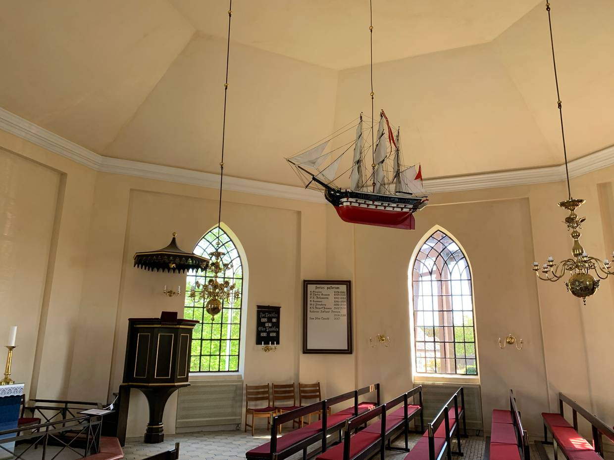 Schiffsmodell an der Decke einer weißen Kirche