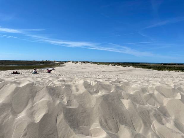 Blick von der Wanderdüne in Richtung Meer, Menschen entspannen im Sand