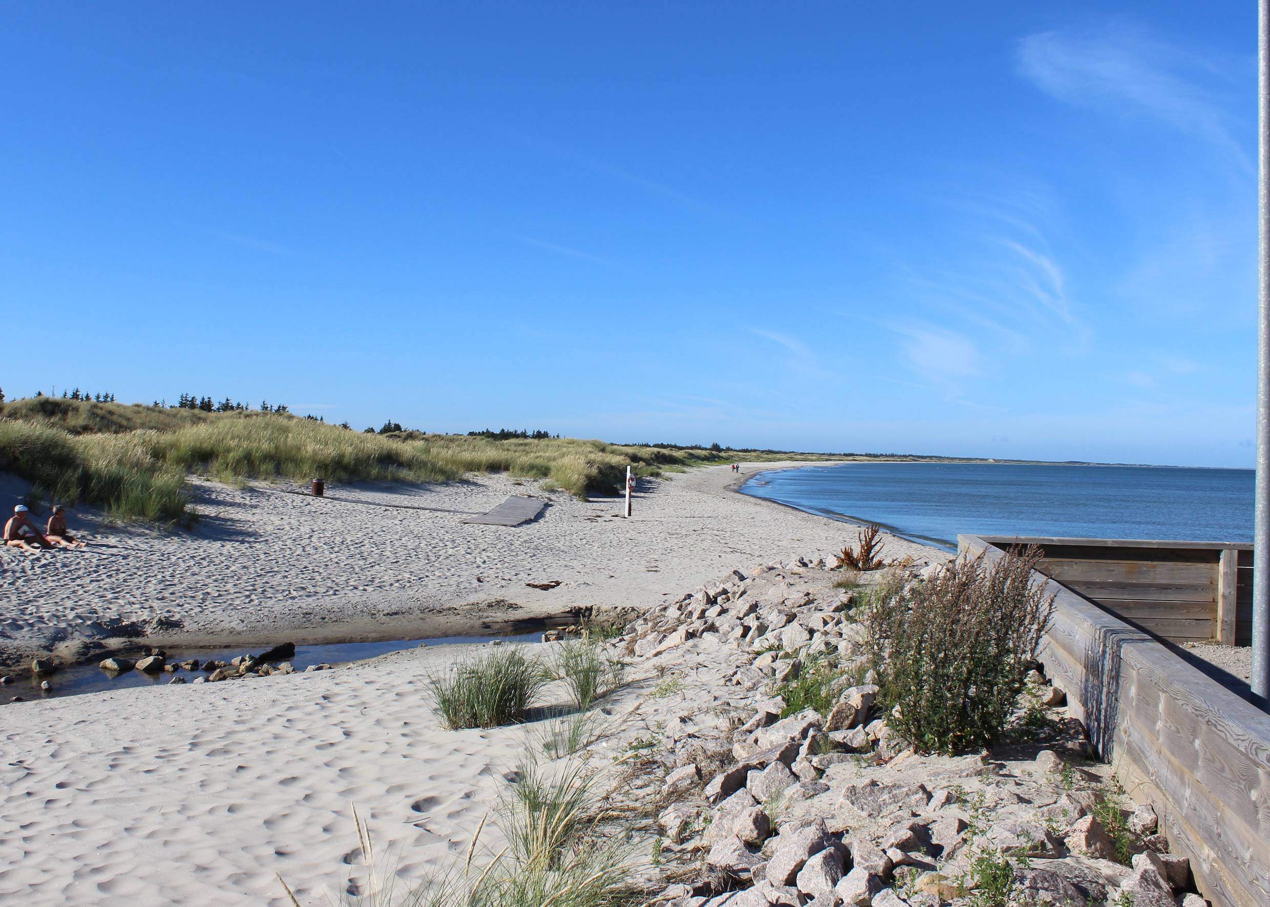 Sandstrand mit einem kleinen Bachlauf bei Sonne