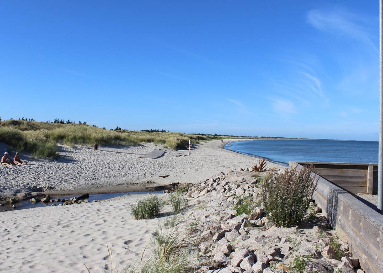 Sandstrand mit einem kleinen Bachlauf bei Sonne