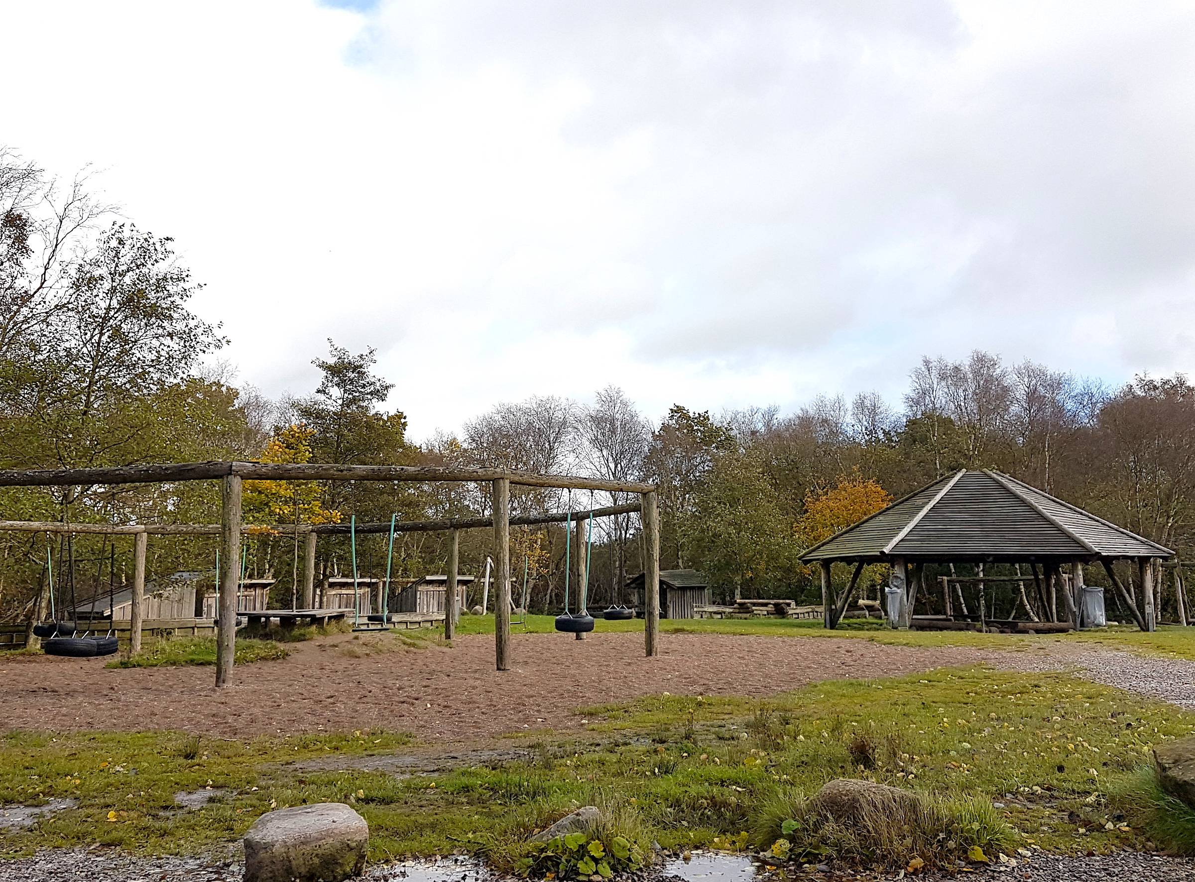 Picknickhütte und Schaukelgerüste auf einer Lichtung