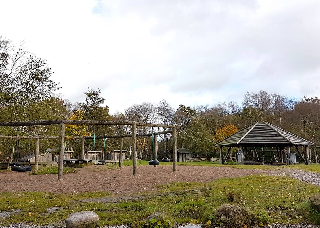 Picknickhütte und Schaukelgerüste auf einer Lichtung