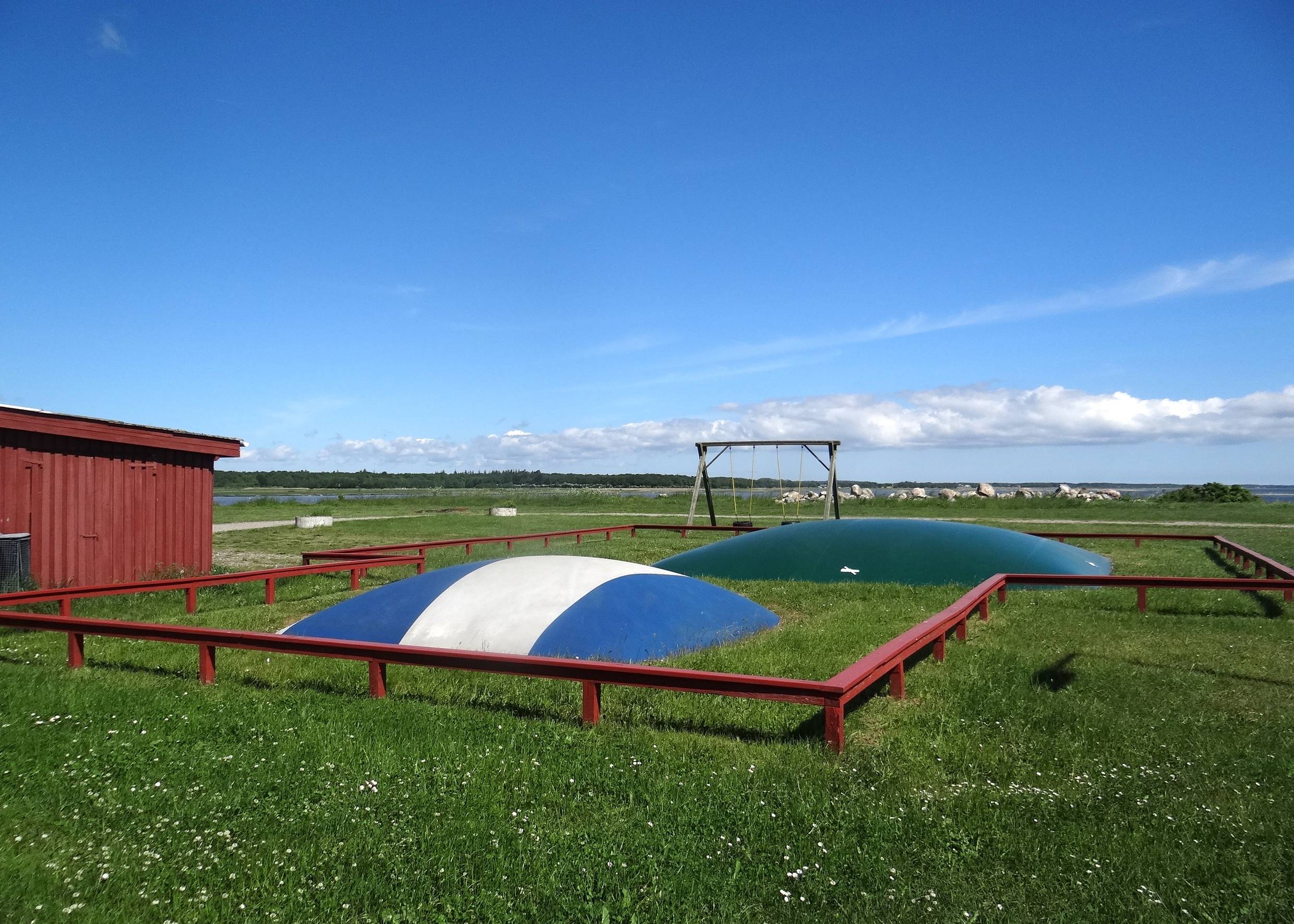 Hüpfkissen und Schaukeln auf einer Wiese